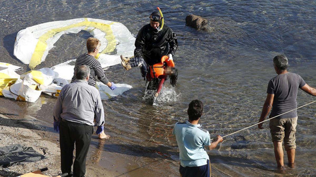 Un guardacostas griego saca del agua el cadáver de un niño refugiado en la costa griega de Lesbos.