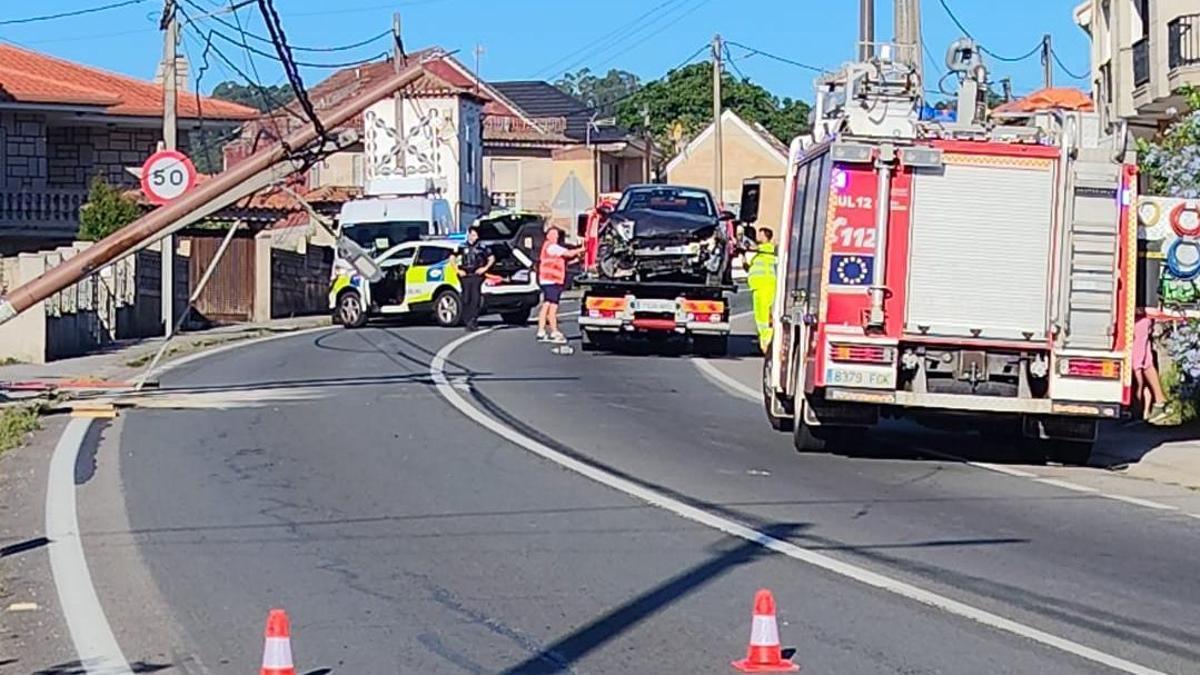 La grúa con el coche accidentado, Policía Local de Moaña y los bomberos en el lugar del suceso.
