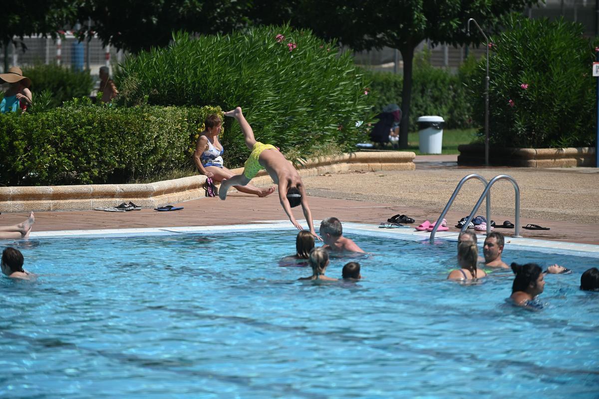 Un joven saltando a la piscina