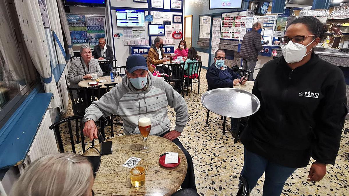 Una camarera del Bar O Pósito, de Moaña, sirviendo ayer a dos clientes. |   // SANTOS ÁLVAREZ