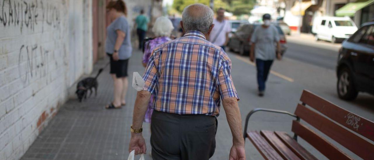 Un hombre camina con una bolsa por el barrio de San Lázaro. |