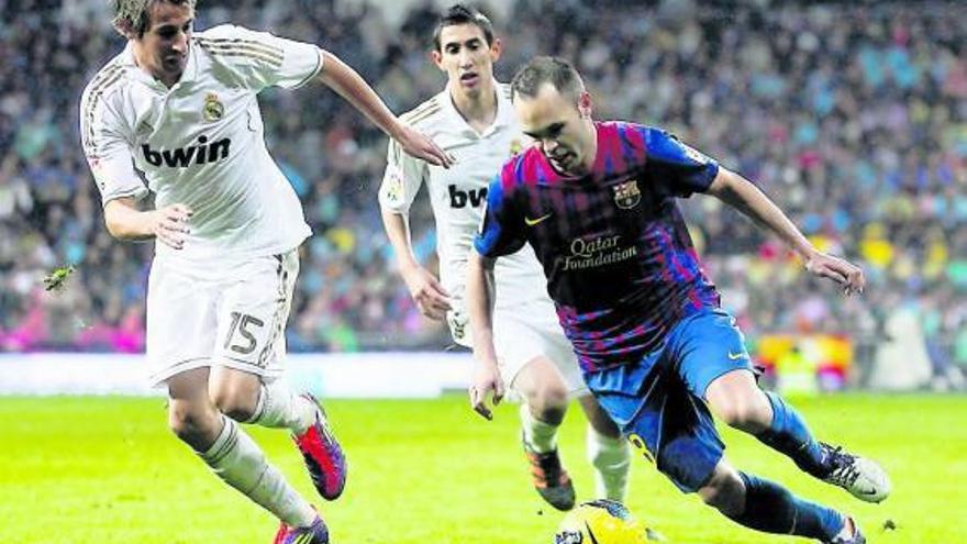 Coentrão persigue a Iniesta durante el Real Madrid-Barcelona de la primera vuelta.