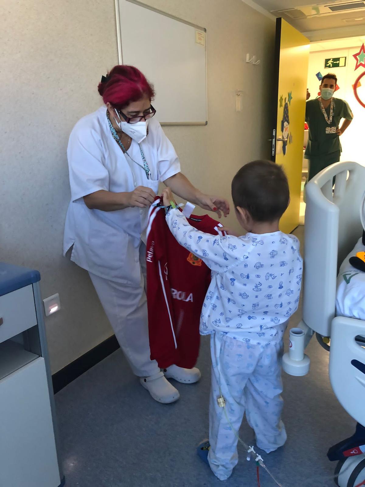 Un niño recibe su camiseta en el hospital.