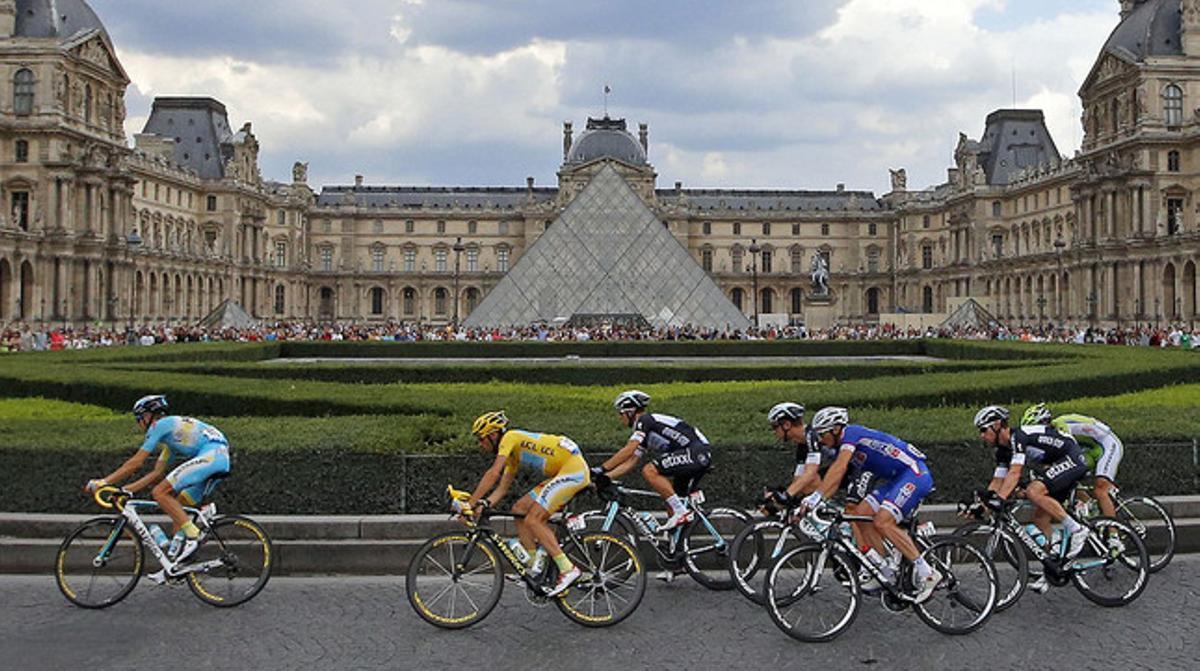 El pilot circula al costat del museu del Louvre, en l’última etapa del Tour.