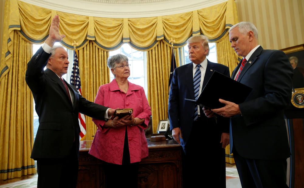 El vicepresidente Mike Pence hace jurar a Jeff Sessions bajo la atenta mirada de Donald Trump. Mary Sessions sostiene la biblia sobre la que jura su marido.