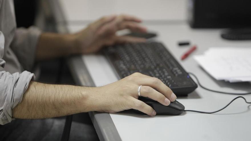 Un trabajador utiliza un ordenador en su puesto de trabajo