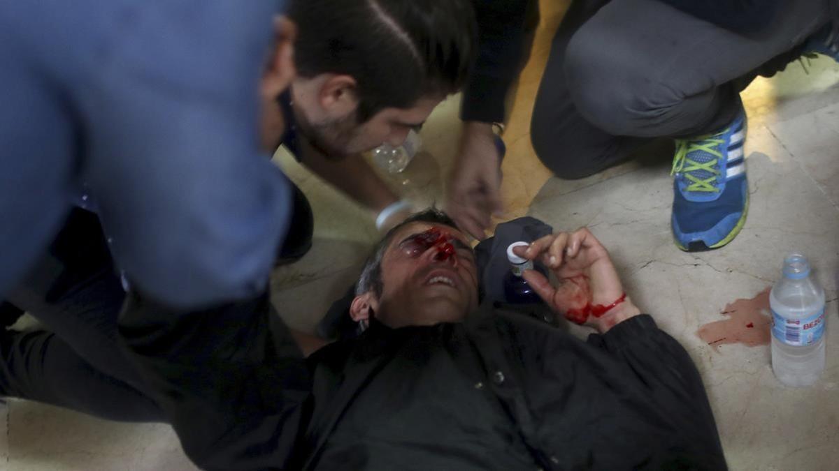 Un manifestante es atendido después de ser golpeado por una bala de goma disparada por la Policía Nacional de España cerca de la escuela Ramón Llull