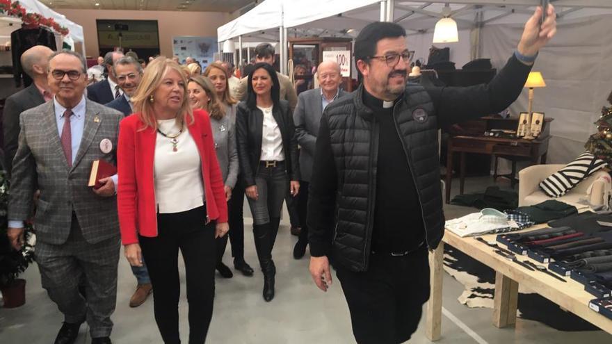 El párroco José López Solórzano bendice el bazar en la inauguración.