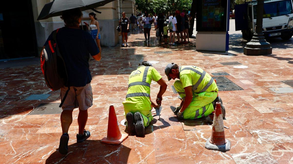Dos operatios trabajando al sol en una jornada con dos muertes por golpe de calor.