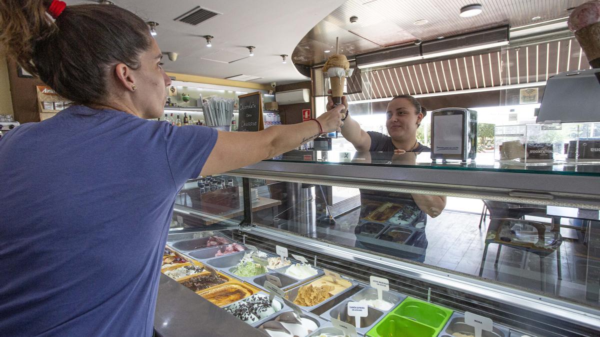 Una dependienta sirviendo helados en un establecimiento artesanal de Alicante.