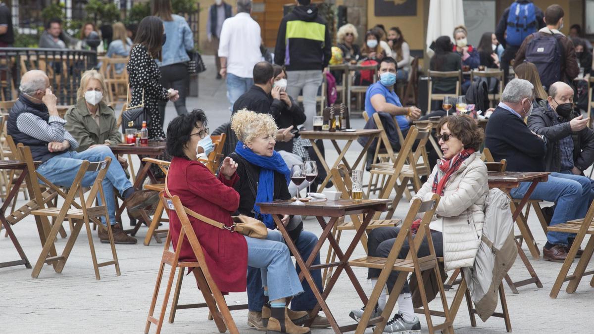 Grupos de personas sentadas en una terraza.