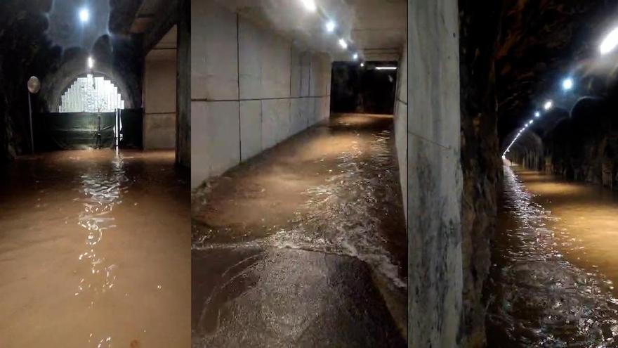 El túnel peatonal del Parque de Invierno se convierte en una piscina tras la inesperada tromba de agua que cayó esta tarde en Oviedo