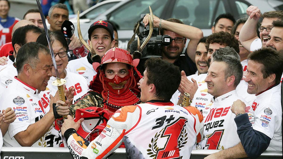 Un mecánico disfrazado de samurái entrega una katana a Marc Márquez tras proclamarse bicampeón de MotoGP