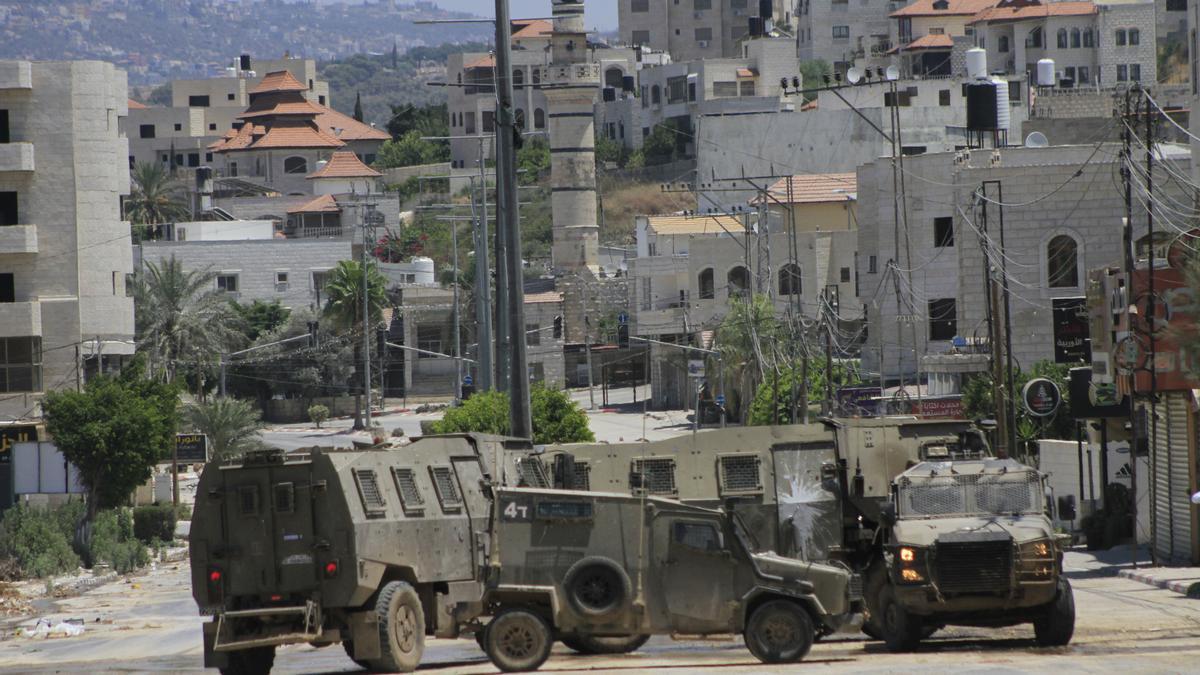 Vehículos militares israelíes patrullan la calle durante una incursión de las fuerzas israelíes en un campo de refugiados en Tulkarem (Cisjordania)