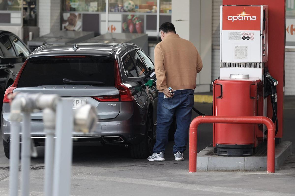Un conductor reposta combustible, en una gasolinera.