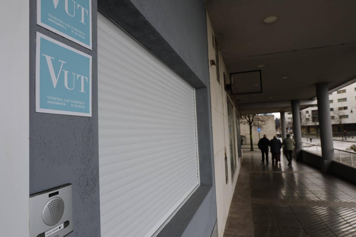 Placas señalizando viviendas de uso turístico en un edificio de Gijón.