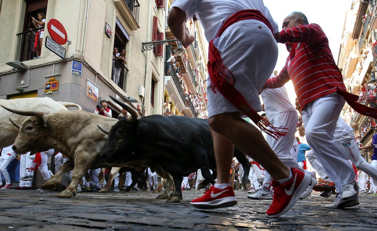 Revellers sprint in front of bulls during the fifth running of the bulls of the San Fermin festival in Pamplona, Spain, July 11, 2018. REUTERS/Susana Vera