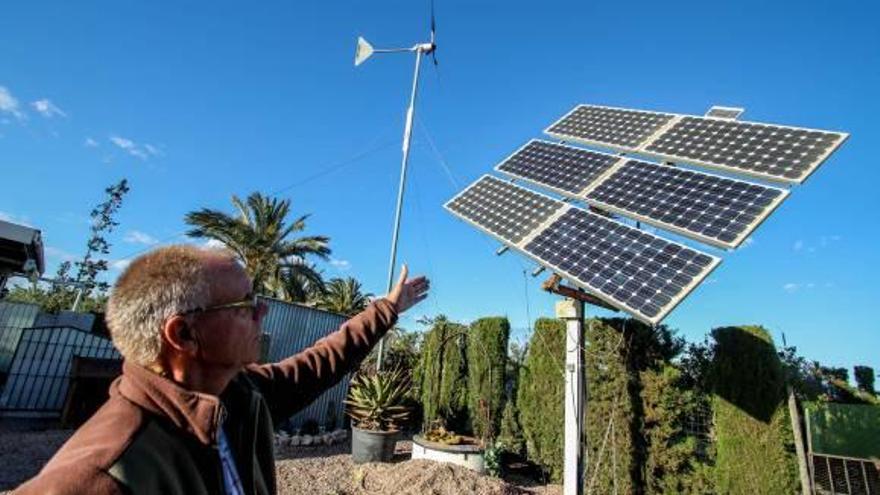 Un vecino de una pedanía ilicitana muestra las placas solares y el aerogenerador de su casa.