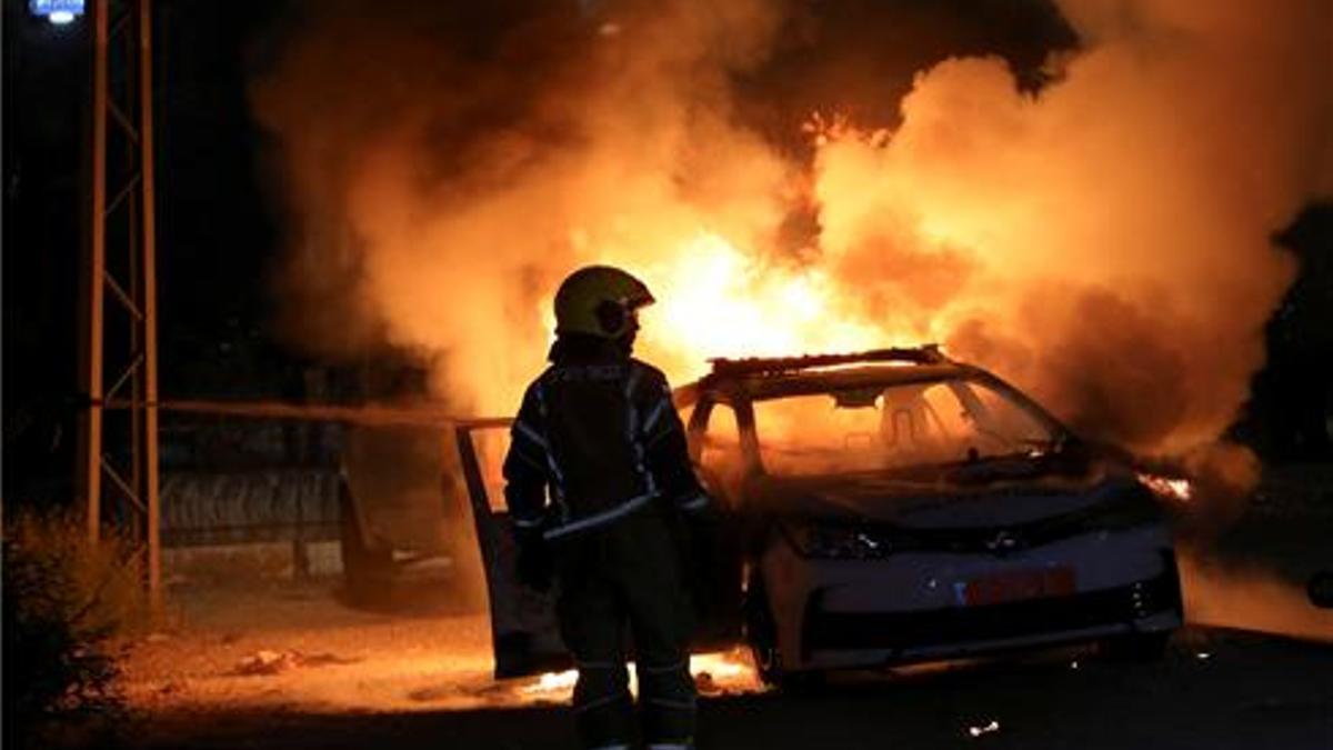 Un coche de la policía incendiado durante los choques en la ciudad de Lod.