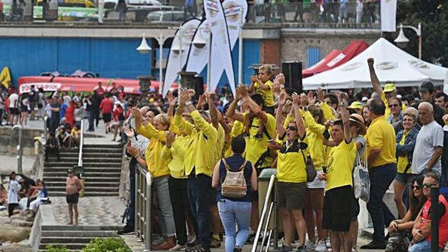 Miembros de un club de traineras y turistas siguen la regata en Riazor.