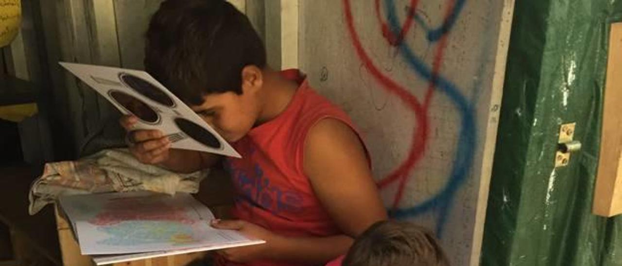 Bestard, en el centro, durante uno de los talleres en las afueras de Cherso. A la derecha, dos niños miran a través de filtros de colores varios dibujos de la ilustradora.