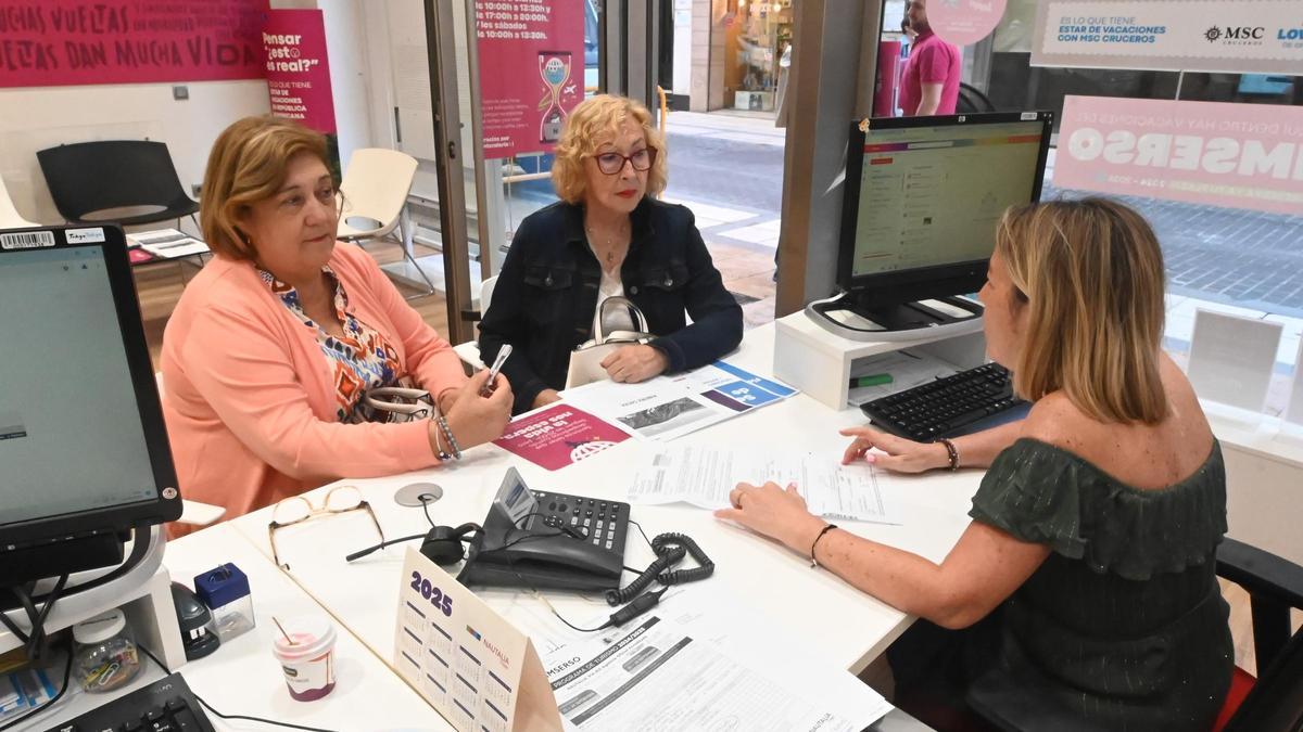 Dos mujeres beneficiarias del programa del Imserso, en una agencia de viajes de Castelló.
