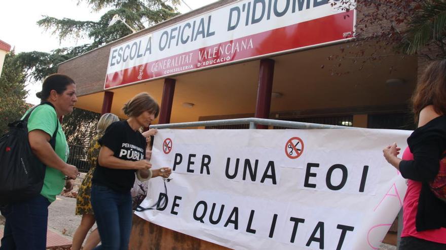 Profesores colocando una pancarta reivindicativa