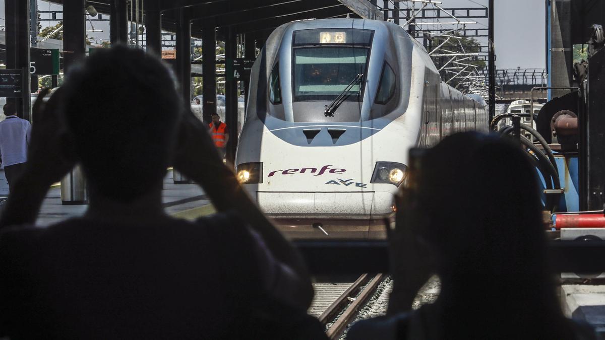 Dos viajeros fotografían la llegada de un tren a la Estación de Córdoba.