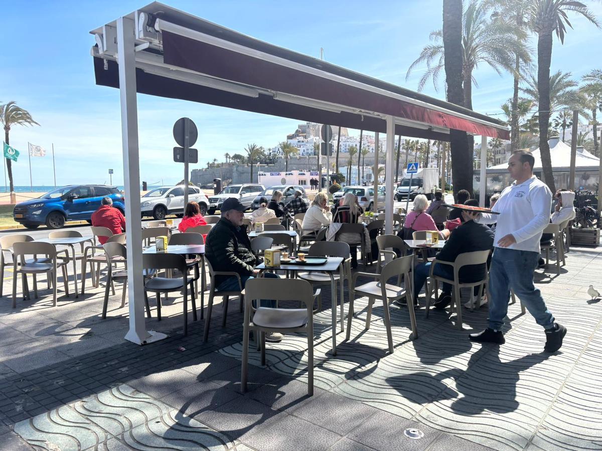 Un camarero presta servicio en una terraza frente al mar, durante estos días, en Peñíscola.