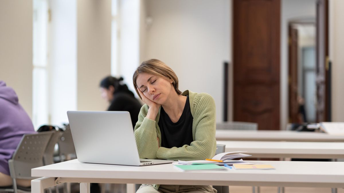 Sleepy bored middle-aged woman mature student falling asleep during boring online class