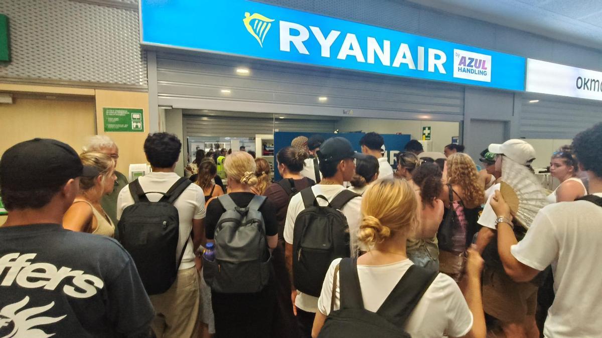 Los afectados por la reprogramación del vuelo de Ryanair, frente a la ventanilla de la compañía.