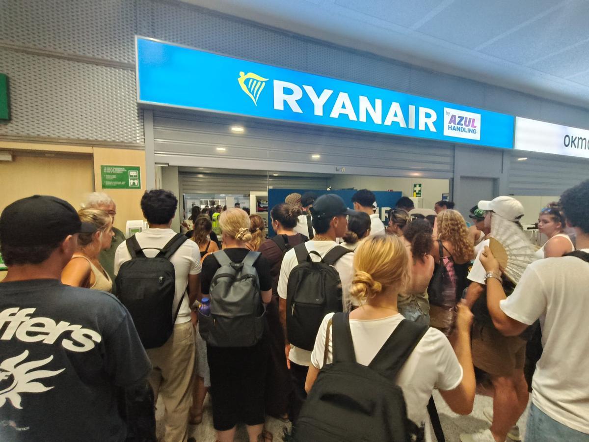 Los afectados por la reprogramación del vuelo de Ryanair, frente a la ventanilla de la compañía.