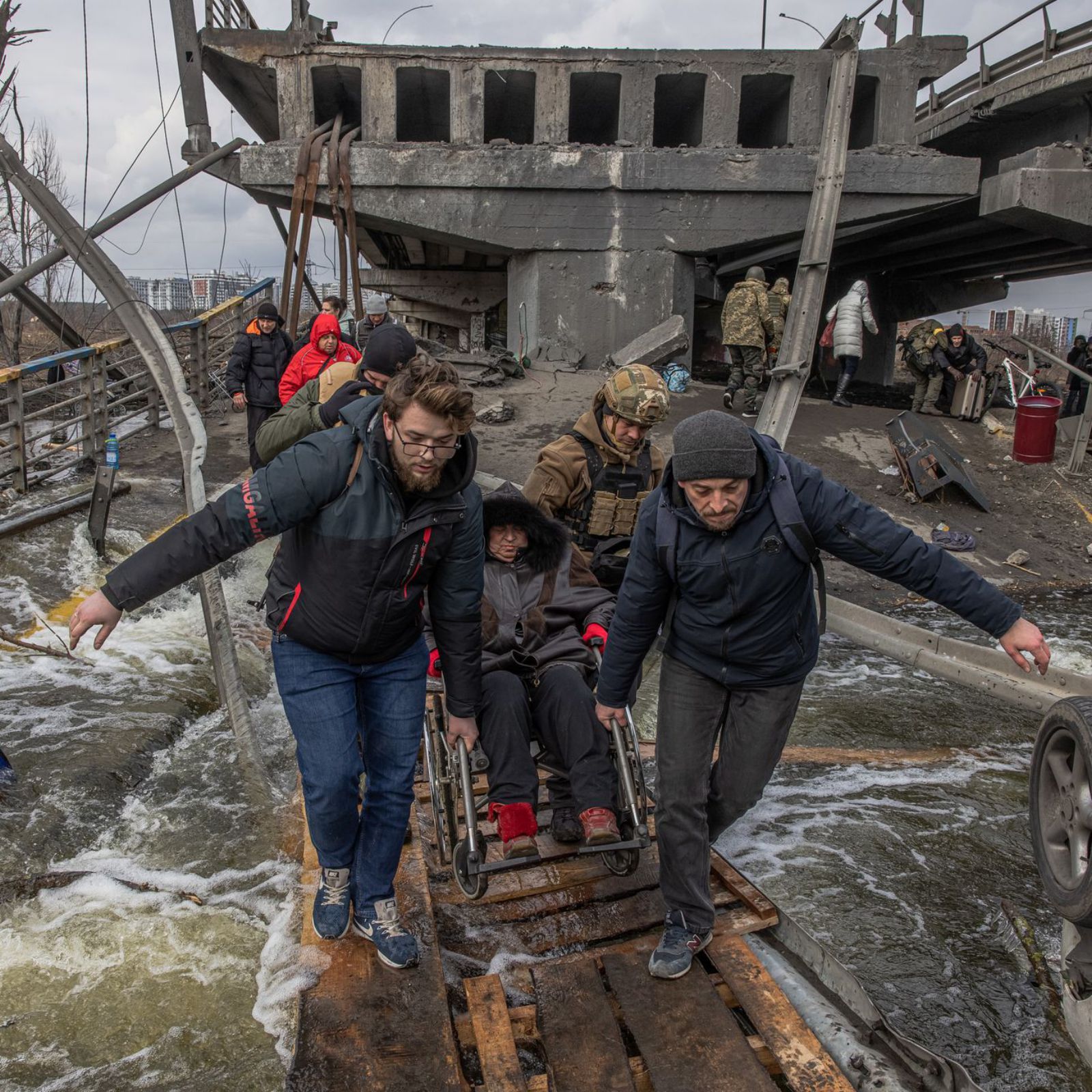 Unas personas cruzan el
un puente en Kiev destrozado 
por las bombas.   | // EFE / R. PILIPEY