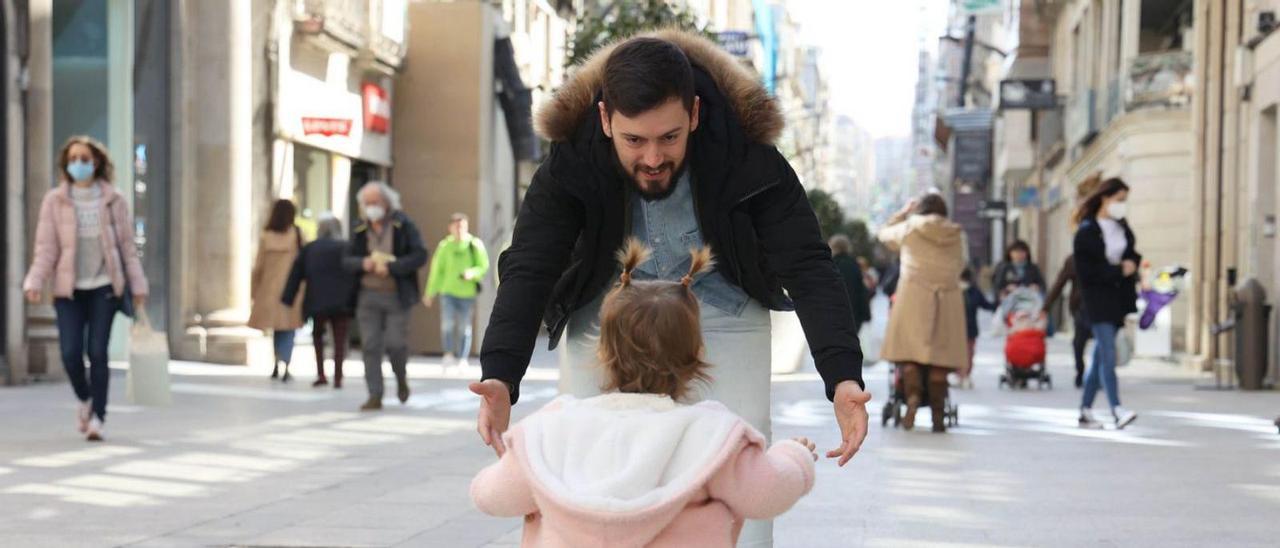 Un padre juega con su hija en el centro de Vigo.   / ALBA VILLAR