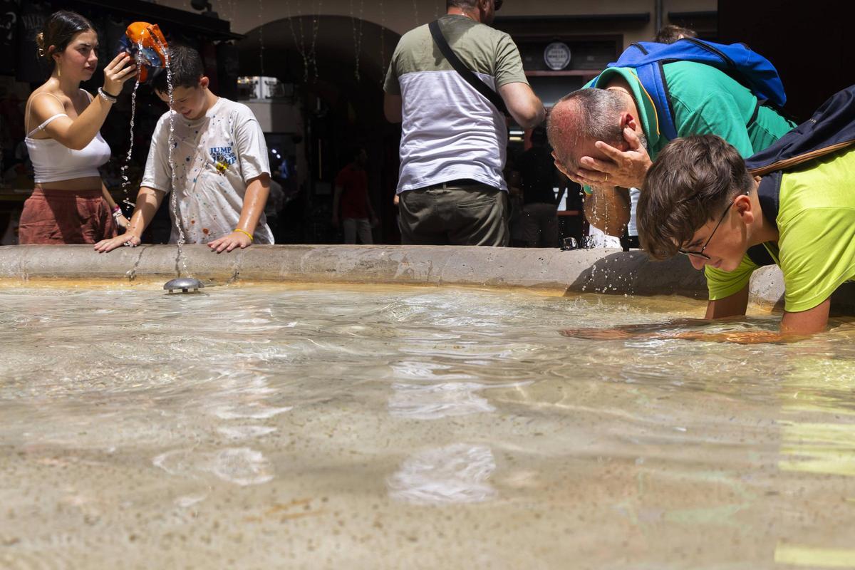 Turistas refrescándose en la fuente de la plaza redonda de València el pasado 10 de agosto, el día más caluros del verano.