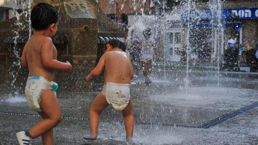 Los niños se refrescaron con un divertido baño en la fuente de la reformada plaza. // Iñaki Abella