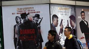 Dos joves caminen davant d’un cartell anunciador de la pel·lícula de Tarantino, en un cine del país asiàtic.