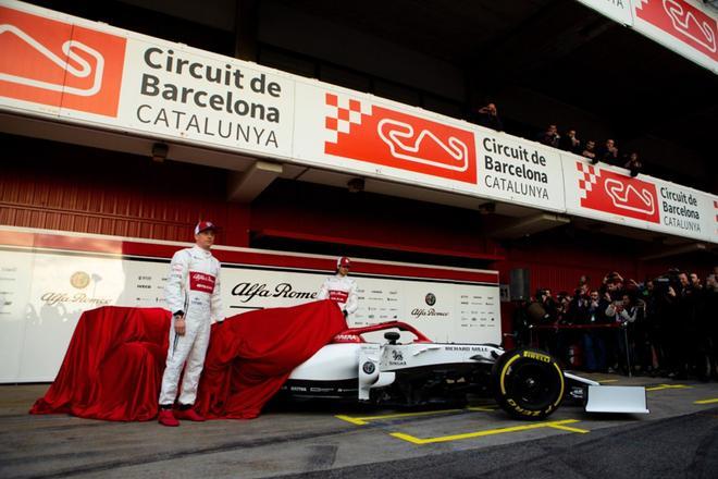 El piloto finlandés, Kimi Raikkonen (L) y el piloto italiano, Antonio Giovinazzi (R), posan después de desvelar el nuevo automóvil de fórmula uno de Alfa Romeo Sauber en el Circuit de Catalunya en Montmeló en las afueras de Barcelona.