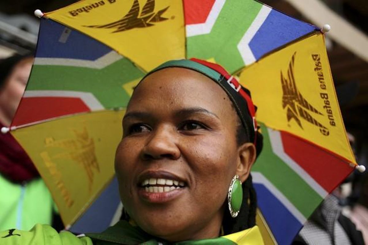 Una dona amb un barret paraigua amb els colors sud-africans, assisteix a l’acte.