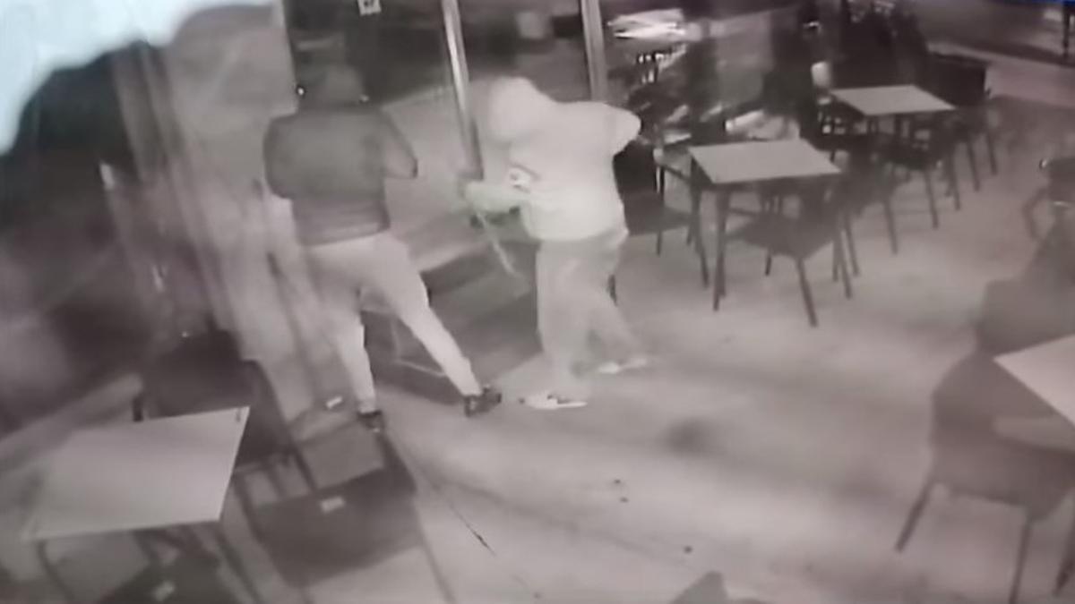 Captura de pantalla de la grabación de la cámara de seguridad en la que se ve a los dos individuos intentando forzar la puerta