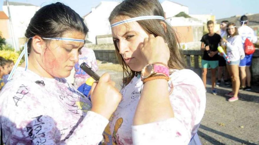 Dos &quot;quintas&quot; del pasado año con sus camisetas empapadas en vino en la plaza do Regueiro. // Noé Parga