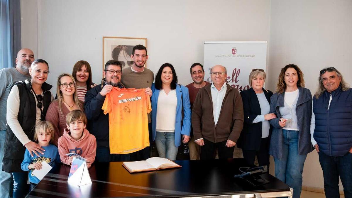 Llopis y el alcalde junto a familiares, concejales y el entrenador del atleta, el día en que regaló la camiseta a Bellreguard