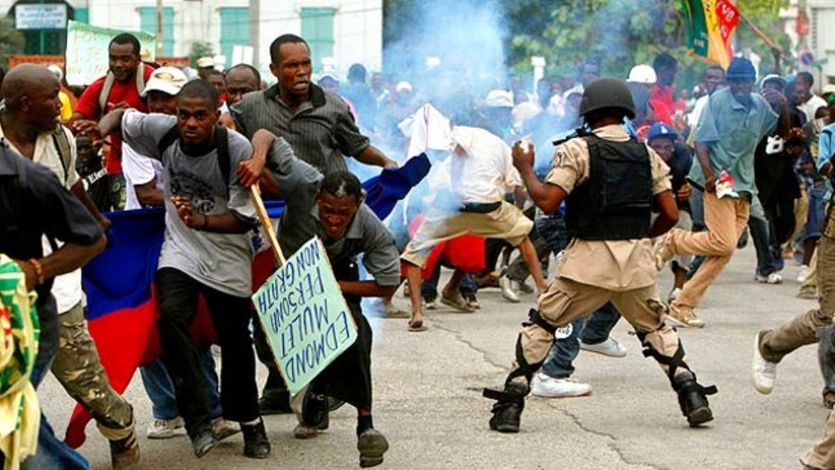 Un grup de manifestants a Port-au-Prince (Haití) fugen del gas lacrimogen durant un enfrontament amb la policia.