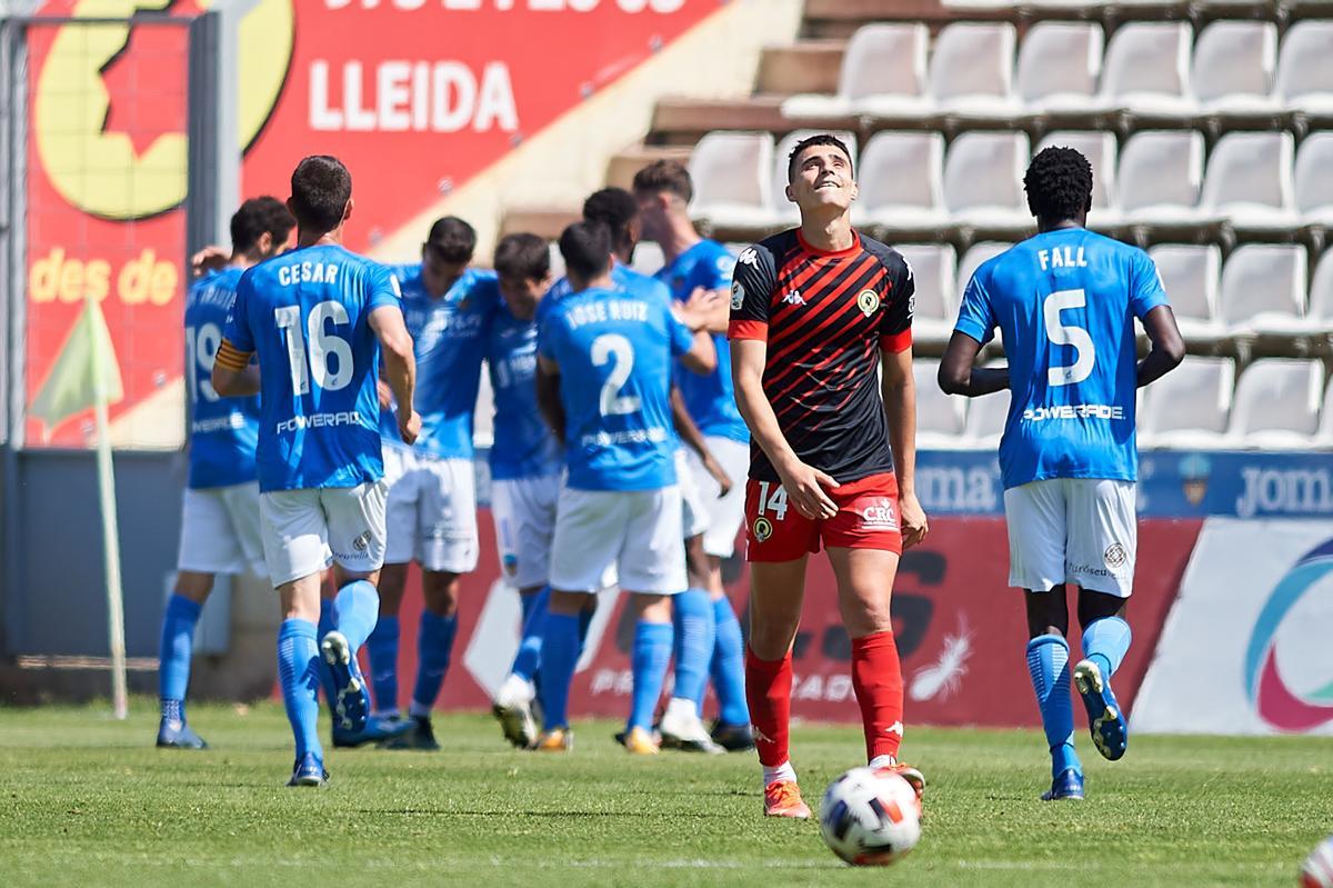 Los jugadores del Lleida celebran el tanto de Abel mientras David Sánchez mira al cielo resignado.