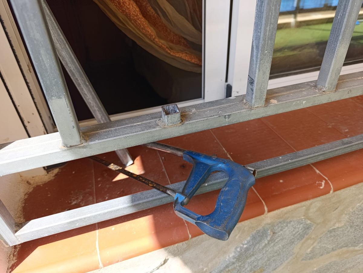 Reja rota con un serrucho.