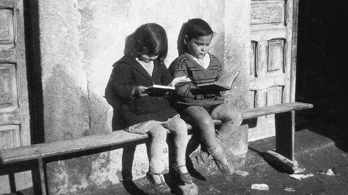 Niños leyendo libros de la biblioteca de las Misiones Pedagógicas.