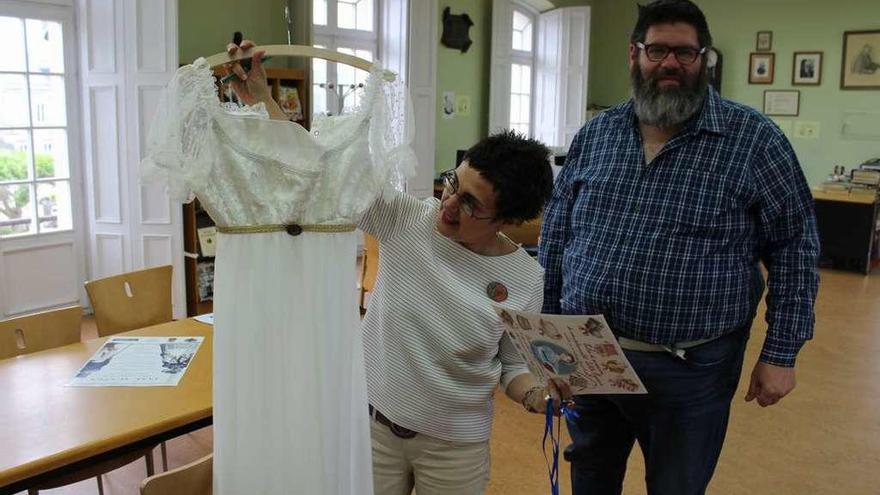 La bibliotecaria Manuela Busto muestra uno de los vestidos que se usarán para la recreación, en presencia del anticuario Roberto Frontera.