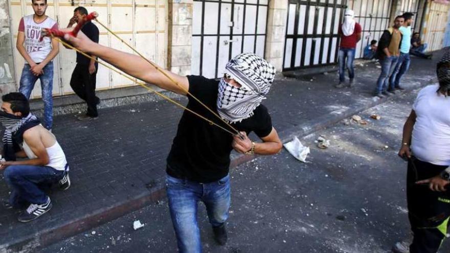 Manifestantes palestinos arrojan piedras contra soldados israelíes en la ciudad cisjordana de Hebrón. // Efe