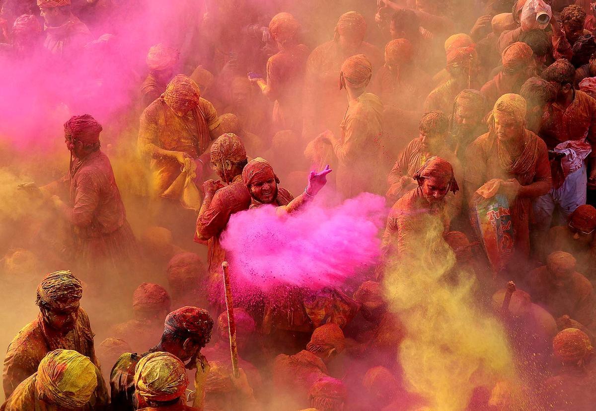 Los devotos hindúes participan en el festival religioso de Holi dentro de un templo en la aldea de Nandgaon, en el estado de Uttar Pradesh, India.