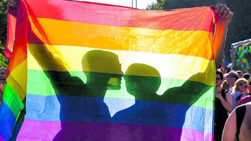 Dos hombres sujetan una bandera durante una manifestación del Orgullo Gay. | JOAN CORTADELLAS